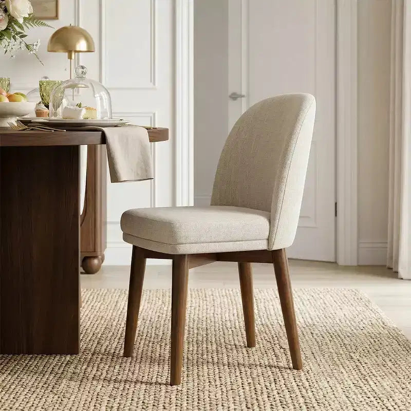 Table à manger ronde de style Mid-Century avec plateau en placage de noyer, piétement croisé en bois massif et chaises en lin avec pieds en bois massif.